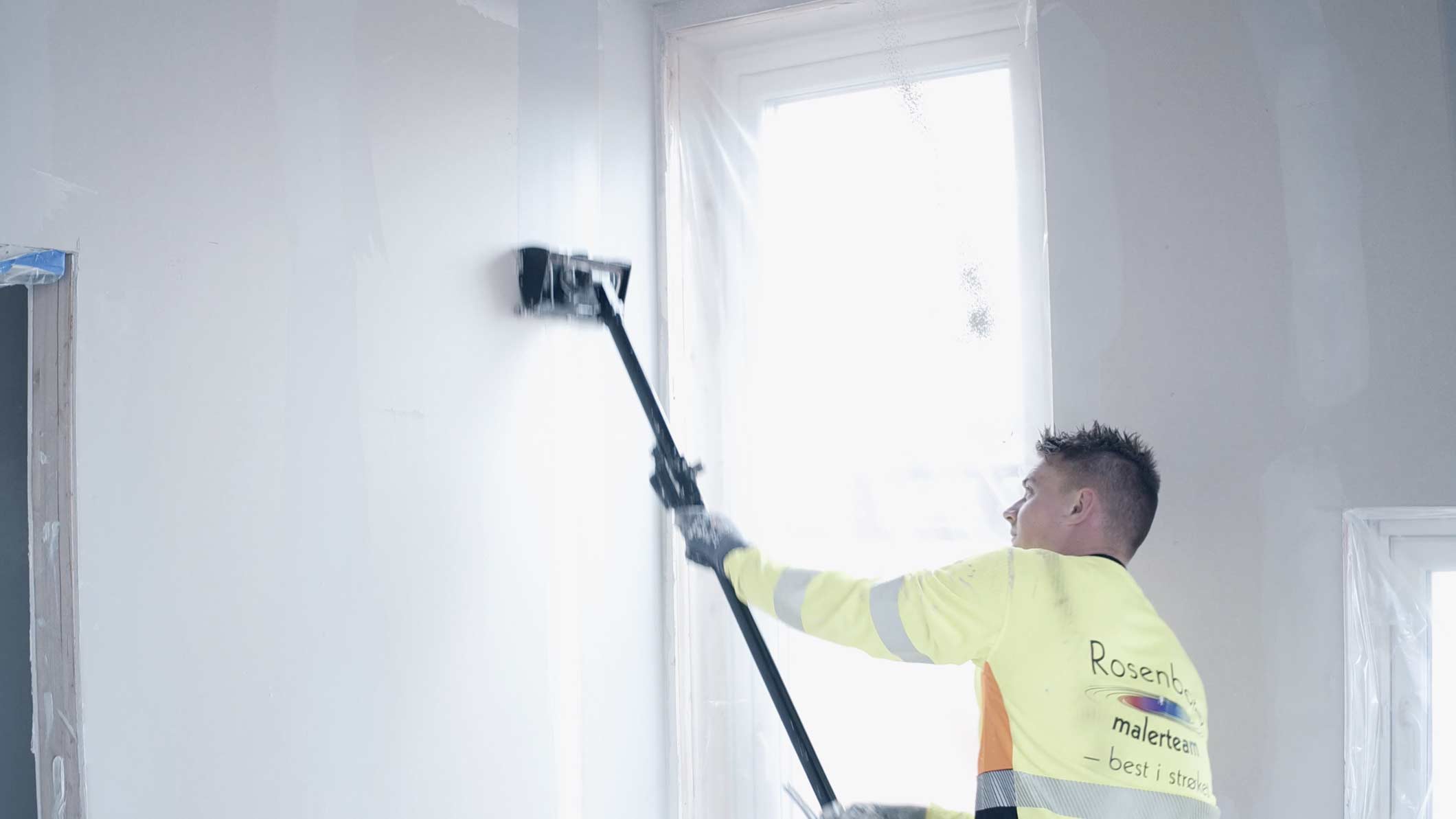 Maler ruller en vegg innvendig